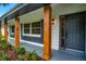 Charming front porch showcasing wood columns, gray shutters, a new exterior paint job, and stylish front door at 5938 Marlberry Dr, Orlando, FL 32819