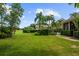 Lush green backyard with mature trees, hedges, and manicured lawn providing a serene and private outdoor space at 6138 Greatwater Dr, Windermere, FL 34786