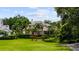 Beautifully maintained home with a lush green lawn, mature trees, and manicured landscaping at 6138 Greatwater Dr, Windermere, FL 34786