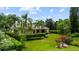 Charming home with tropical landscaping, lush greenery, and a well-manicured lawn on a sunny day at 6138 Greatwater Dr, Windermere, FL 34786