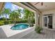 Relaxing outdoor pool area surrounded by palm trees and a covered patio, perfect for enjoying the Florida sunshine at 6138 Greatwater Dr, Windermere, FL 34786