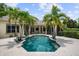 Backyard pool and patio area is surrounded by lush tropical landscaping and mature palm trees at 6138 Greatwater Dr, Windermere, FL 34786