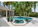 Beautiful pool and spa surrounded by lush landscaping create a backyard oasis with palm trees at 6138 Greatwater Dr, Windermere, FL 34786