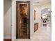 Ornate wine cellar door adjacent to a hallway with a view into the living room with fireplace at 6138 Greatwater Dr, Windermere, FL 34786