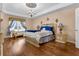 A primary bedroom with luxury bedding, a chandelier and views of the outdoor scenery at 617 Marsh Reed Dr, Winter Garden, FL 34787