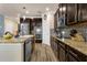 Well-equipped kitchen featuring stainless steel appliances, granite countertops, and dark wood cabinets at 617 Marsh Reed Dr, Winter Garden, FL 34787