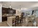 Open-concept kitchen and dining area with granite counters, dark cabinetry, and chandelier lighting at 617 Marsh Reed Dr, Winter Garden, FL 34787
