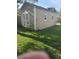 Backyard shed shows light tan color, white trim, double doors, 2 windows, with lawn and a shovel next to it at 740 Naples Dr, Orlando, FL 32804