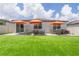 The backyard has a well-maintained lawn with outdoor seating under three umbrellas, perfect for relaxation at 840 Teton St, Haines City, FL 33844