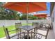 Relaxing backyard patio setup with an outdoor dining area and orange umbrellas at 840 Teton St, Haines City, FL 33844