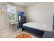 Bright, minimalist bedroom with a workspace, a blue accent wall and carpet flooring at 840 Teton St, Haines City, FL 33844