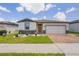 Charming single-Gathering home with a well-manicured lawn, brick driveway, and a two-car garage at 840 Teton St, Haines City, FL 33844