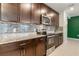 Gourmet kitchen featuring granite countertops, stainless steel appliances, and stylish backsplash at 840 Teton St, Haines City, FL 33844
