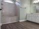 Bathroom with shower-tub combination, modern vanity and dark wood flooring at 8414 Sw 136Th Pl, Ocala, FL 34473