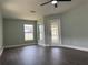 Well-lit bedroom with dark wood flooring, natural light and neutral paint at 8414 Sw 136Th Pl, Ocala, FL 34473