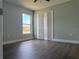 Bedroom featuring large window, bi-fold closet and dark wood flooring at 8414 Sw 136Th Pl, Ocala, FL 34473