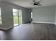 Open living room with dark wood floors, bright lighting and sliding glass doors at 8414 Sw 136Th Pl, Ocala, FL 34473