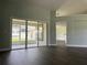 Bright living room with hardwood floors and access to a screened in patio via sliding glass doors at 8414 Sw 136Th Pl, Ocala, FL 34473