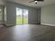 Bright living room featuring dark wood floors, large windows and sliding glass doors at 8414 Sw 136Th Pl, Ocala, FL 34473
