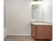 Neutral bathroom featuring a wooden vanity with an undermount sink, ample lighting, and vinyl flooring at 85 Levee Ln, Ormond Beach, FL 32174