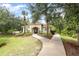 This is a view of the clubhouse surrounded by lush landscaping and sidewalks on a bright day at 85 Levee Ln, Ormond Beach, FL 32174
