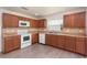 Well-lit kitchen with wooden cabinets, tile backsplash, updated appliances, and laminate wood flooring at 85 Levee Ln, Ormond Beach, FL 32174