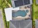 Bird's eye view shows a screened-in pool and spa with a solar panel system for energy efficiency at 8665 Pinter St, Orlando, FL 32827