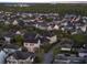 A daytime aerial view showcases a residential neighborhood with lush greenery and nearby trees at 8665 Pinter St, Orlando, FL 32827