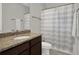 Bathroom featuring granite countertop, bronze fixtures, and shower with striped curtain at 8665 Pinter St, Orlando, FL 32827