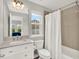 Bathroom featuring a white vanity, white tile, and a shower tub combo with a white curtain at 8665 Pinter St, Orlando, FL 32827