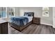 Bedroom with natural light and decor, featuring wood-look floors and a modern-style bed frame at 8665 Pinter St, Orlando, FL 32827