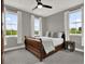 Serene bedroom with three large windows, a ceiling fan, and a cozy bed creating a relaxing retreat at 8665 Pinter St, Orlando, FL 32827