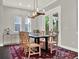 Bright dining room featuring a glass-top table, decorative rug, and a stylish modern chandelier at 8665 Pinter St, Orlando, FL 32827