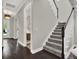 A bright, expansive entryway with stairs and an open view of the powder room, showcasing modern design at 8665 Pinter St, Orlando, FL 32827