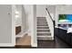 Inviting entryway featuring dark wood floors, a staircase, and a view of the powder room and living room at 8665 Pinter St, Orlando, FL 32827