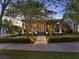 Beautiful two-story home with landscaped yard, stone accents, and a cozy front porch illuminated by landscape lighting at 8665 Pinter St, Orlando, FL 32827
