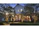 Stunning two-story home with a lush green lawn and a charming front porch, illuminated beautifully at twilight at 8665 Pinter St, Orlando, FL 32827