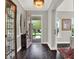Elegant foyer with dark hardwood floors, stylish decor, and a view of the open front door at 8665 Pinter St, Orlando, FL 32827