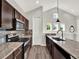Modern kitchen with stainless steel appliances, granite countertops, and dark wood cabinets at 8665 Pinter St, Orlando, FL 32827