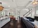 Spacious living room featuring a staircase, open layout to dining, dark floors, and modern light fixtures at 8665 Pinter St, Orlando, FL 32827