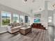 Bright living room featuring wood floors, tan sofa, and large windows at 8665 Pinter St, Orlando, FL 32827