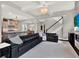 Spacious living room open to kitchen, featuring stairs, elegant lighting, and leather seating at 8665 Pinter St, Orlando, FL 32827