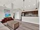 Open-concept living room featuring modern gray floors, a large kitchen island, and high ceilings at 8665 Pinter St, Orlando, FL 32827