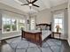 A relaxing main bedroom featuring a wooden framed bed and decorative blue rug, with many windows at 8665 Pinter St, Orlando, FL 32827