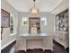 Stylish office showcasing a large glass-top desk, custom shelving, and plenty of natural light at 8665 Pinter St, Orlando, FL 32827
