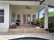 Inviting covered patio with outdoor seating and pink doors, ideal for relaxation at 8665 Pinter St, Orlando, FL 32827