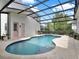 The private pool and spa is encompassed by a screened enclosure and travertine pavers at 8665 Pinter St, Orlando, FL 32827