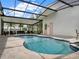 Stunning screened-in pool and patio featuring travertine tile and ample seating space at 8665 Pinter St, Orlando, FL 32827