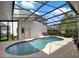 A screened pool with an attached spa and lounge seating at 8665 Pinter St, Orlando, FL 32827