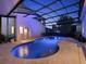 View of a beautiful screened pool and spa with travertine pavers at 8665 Pinter St, Orlando, FL 32827